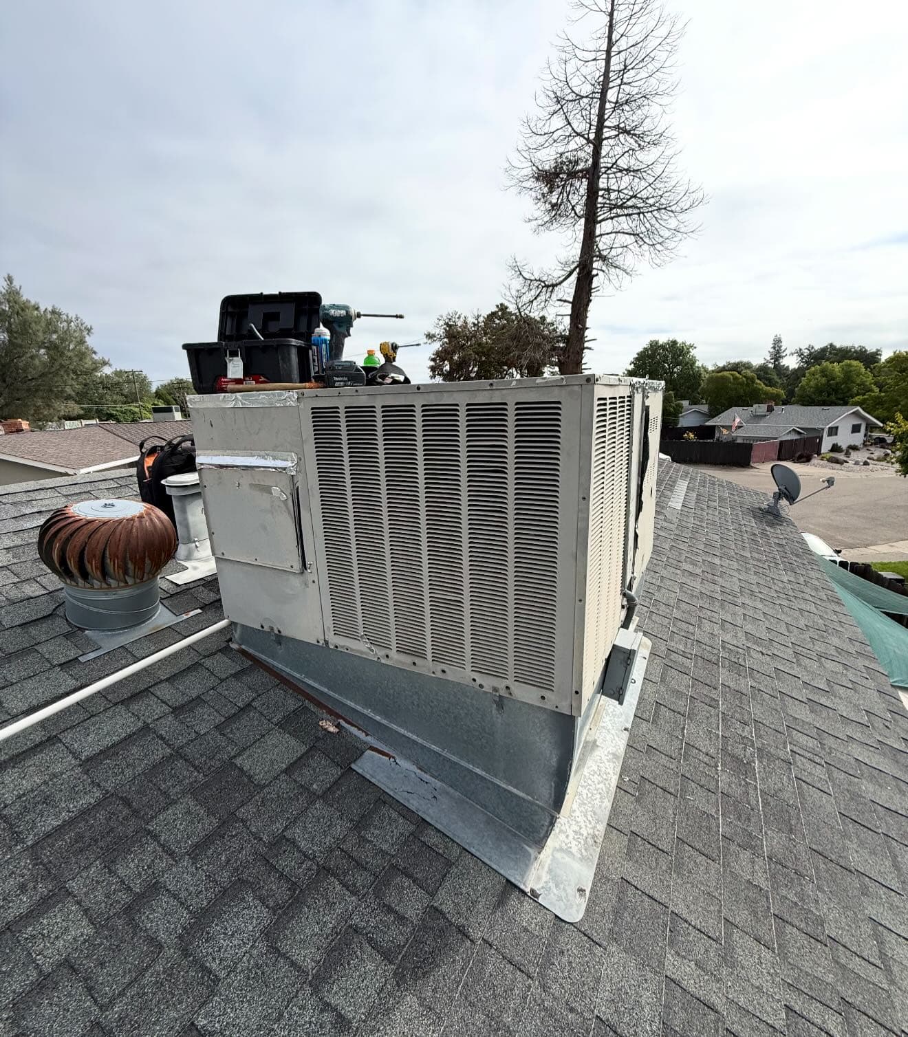New rooftop heat pump replacing an aging package unit, roof patched by a licensed roofer.